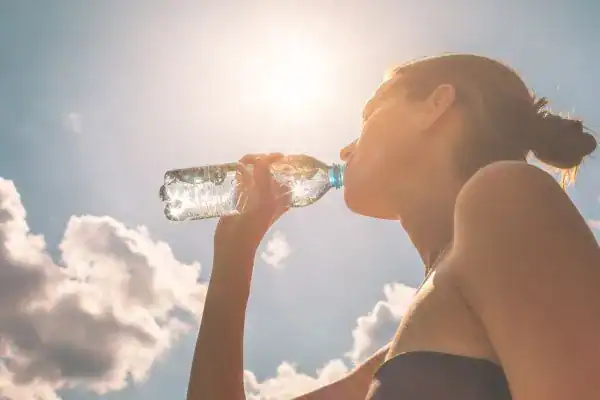 Hydration: The Secret Ingredient for a Toned Stomach and Enhanced Fitness 3 Image of woman drinking water to hydrate West Malling after run.