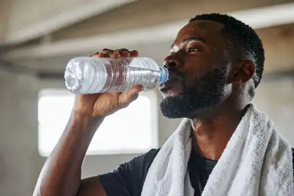 Image of man drinking water to improve hydration West Malling after work out.